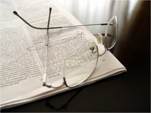 Image of reading glasses on open newspaper